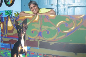 Ileana posa detrás de uno de los cuadros de la serie De la luz a la sombra en su estudio El gato azul.